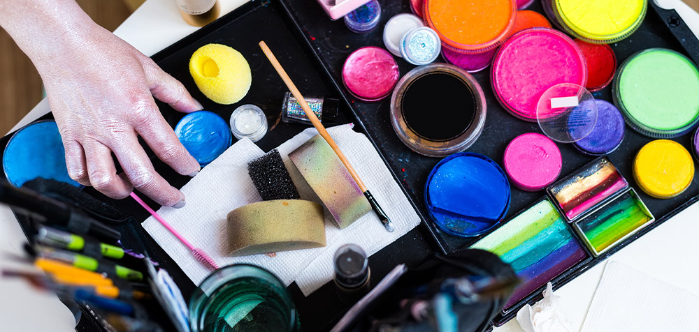 Tavolo con sopra appoggiati colori per disegnare sulla pelle