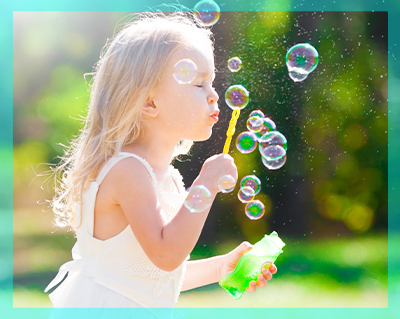 Bambina che gioca con le bolle di sapone