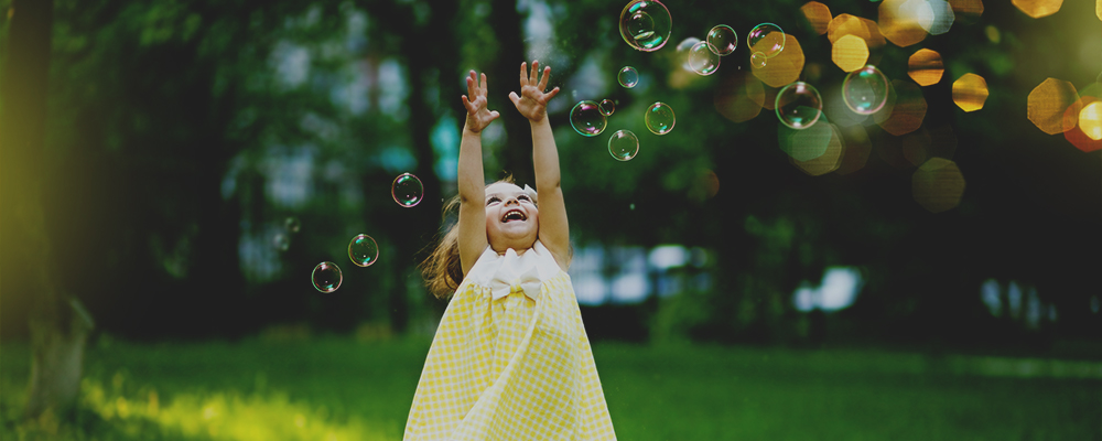 bambina gioca con bolle di sapone